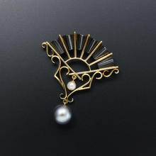 Gold and oxidized silver fan pendant with black and white pearls