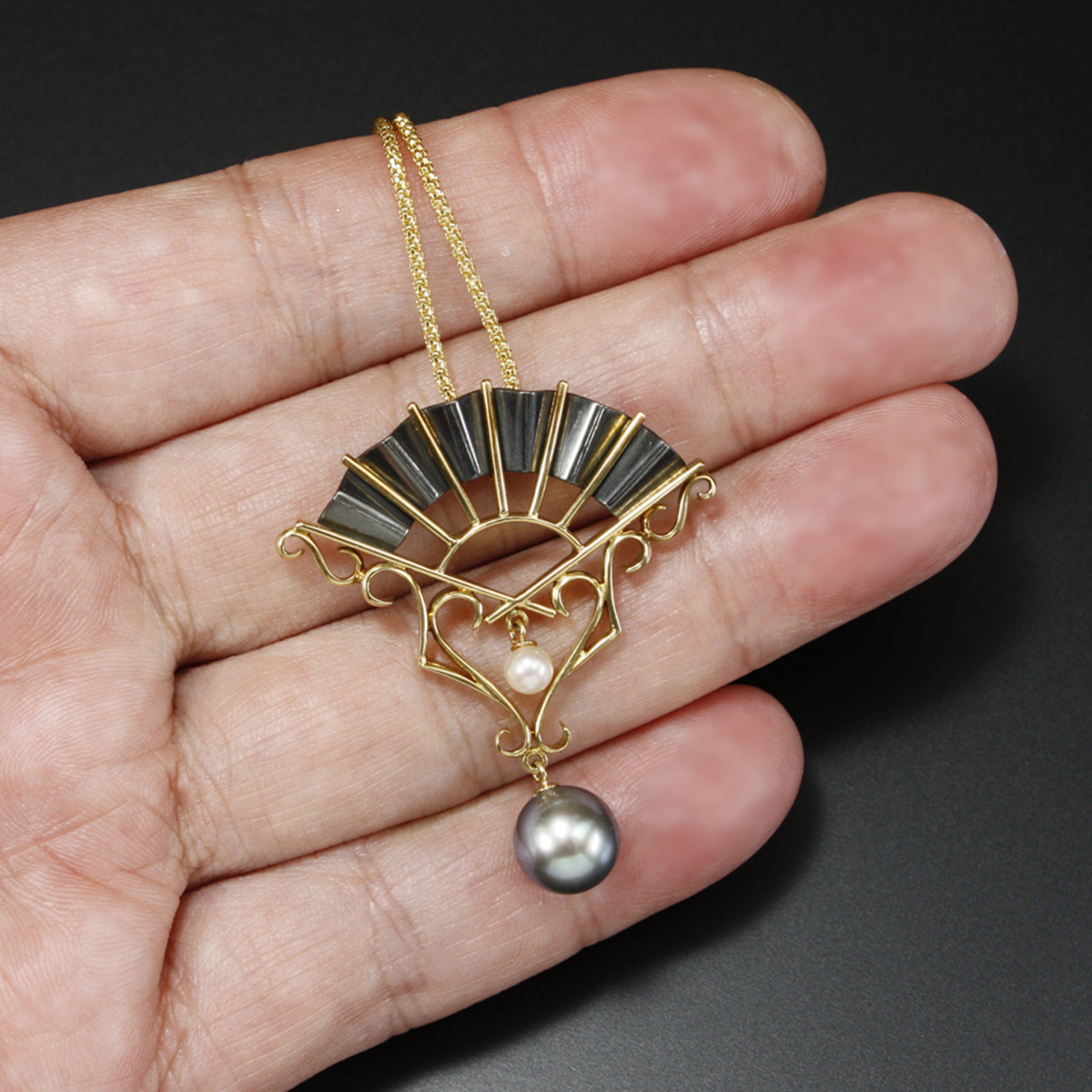 Gold and oxidized silver fan pendant with black and white pearls